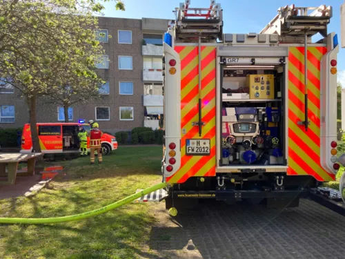 Zwei Autos der Feuerwehr stehen vor einem Haus.